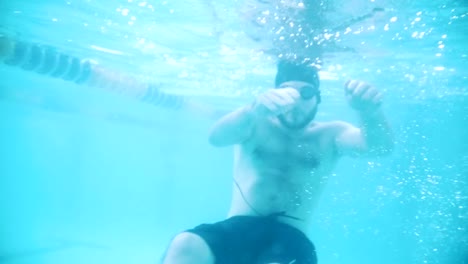 Disabled-man-swims-in-a-swimming-pool.-Underwater-shot