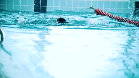 Behinderte-Mensch-schwimmt-auf-der-Rückseite-in-einem-Schwimmbad.-Slow-motion