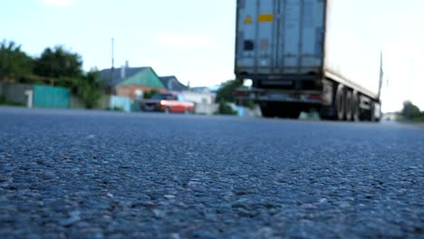 Verschwommen-Autos-gehen-eins-nach-dem-anderen-auf-der-Straße.-Fahrzeuge-fahren-auf-asphaltierten-Straße.-Verkehr-in-Autobahn.-Niedrigen-Winkel-Ansicht-Zeitlupe