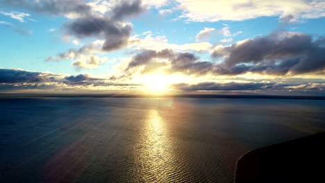 The-flight-above-the-water-on-the-sunset-background.-time-lapse