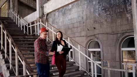 Der-Vorarbeiter-zeigt-einer-Ingenieurin-die-Menge-an-Arbeit-auf-der-Baustelle-erforderlich.