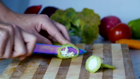 Chef-is-cutting-vegetables-in-the-kitchen,-slicing-sweet-green-bell-pepper.-Close-up-footage