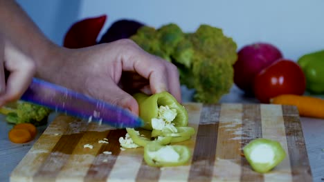 Chef-is-cutting-vegetables-in-the-kitchen,-slicing-sweet-red-bell-pepper