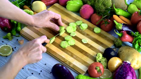 Man-is-cutting-vegetables-in-the-kitchen,-slicing-cucumber