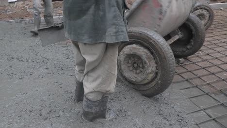 close-up-of-construction-workers-pouring-cement-on-a-rural-road