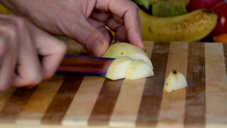 Man-is-cutting-pear-on-cutting-board