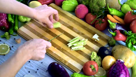 Man-is-cutting-vegetables-in-the-kitchen,-slicing-green-bell-pepper