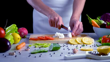 Man-is-cutting-vegetables-in-the-kitchen,-slicing-red-radish