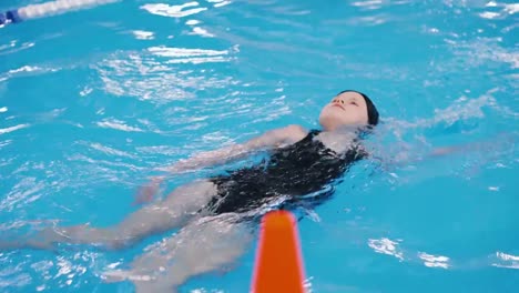 Schwimmkurse-für-Kinder-in-den-Pool---schönes-hellhäutige-Mädchen-im-Wasser-schwimmt