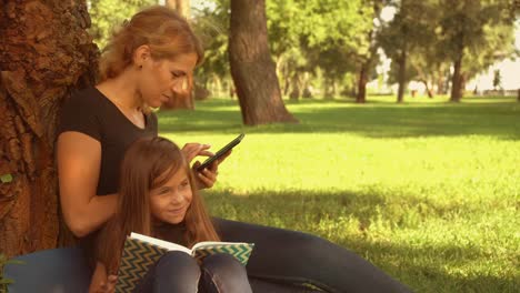 mother-sitting-by-the-tree-with-her-daughter