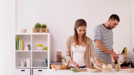 glückliches-Paar-Kochen-und-servieren-von-Speisen-zu-Hause