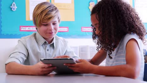 Dos-niños-de-escuela-primaria-utilizando-la-tablet-PC-en-una-lección