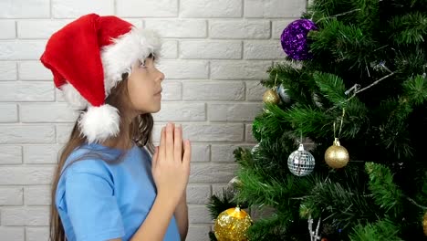 The-child-prays-at-the-Christmas-tree.