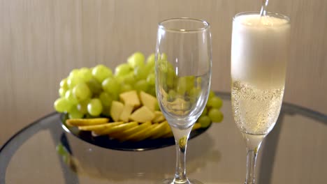 Romantic-date.-Spilling-champagne-in-glasses-on-a-table-with-fruit