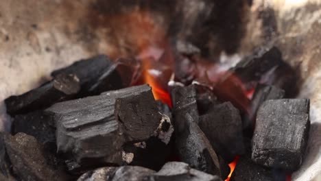 Licking-flame-from-fire-charcoal-in-thai-traditional-stove-with-pine-stick