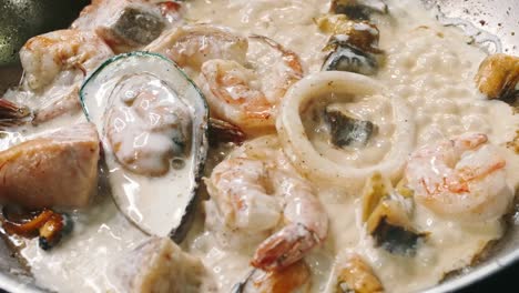 Fragrant-prawns,-mussels-and-fish-are-fried-in-a-saucepan-in-a-frying-pan-in-slow-motion-in-4k-resolution