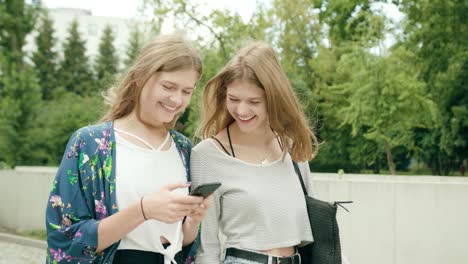 Young-Ladies-Using-a-Phone-in-Town