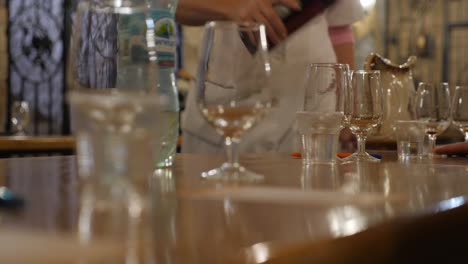Wine-tasting-in-the-tasting-room.-Excursion-around-the-winery-of-Crimea.-Bakaly-stand-on-the-table.-Wine-is-poured-into-a-glass-dish.-Sommelier-extends-his-hand-to-his-glass.-SUNNY-VALLEY