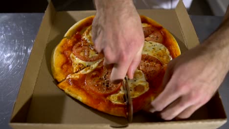 Man-chef-cuts-the-mouth-watering-hot-and-delicious-pizza-close-up