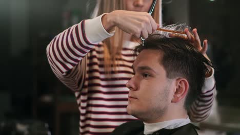 Friseur-Haare-schneiden-mit-professionellen-Schere-und-Kamm-in-Friseur-Salon.-Haarschneider,-männliche-Frisur-mit-Schere-in-Friseurfachschule-hautnah