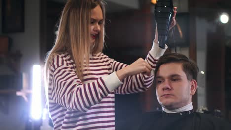 Barbier,-trocknen-Haarausfall-im-Friseursalon.-Bläst-Man-Haare-mit-Trockner-im-Friseursalon-Friseur-hautnah.-Männlich-hairstylish-tun-Frisur-im-Beauty-studio