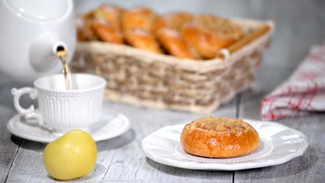 Open-buns-with-apples-Vatrushka-and-shtreyzelem.-Pouring-tea-into-the-cup.