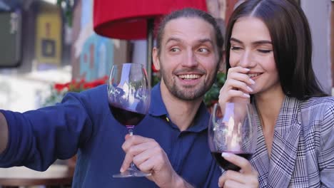 Happy-Couple-With-Wine-Taking-Photos-On-Phone-At-Restaurant