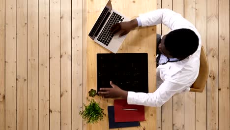 Personal-sanitario-hombre-intelectual-americano-afro-con-labcoat-blanco,-mirando-la-imagen-radiográfica-de-la-radiografía-de-cerebro,-tomografía-computarizada,-resonancia-magnética