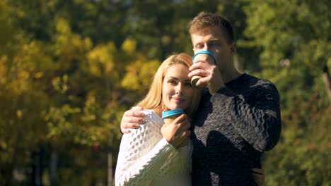 Paar-Verkostung-heiße-Getränke-im-Park-und-umarmt,-romantisches-Date,-Coffee-to-go