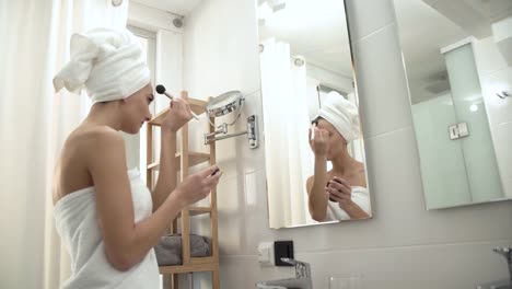 Make-up.-Frau-Auftragen-von-Puder-auf-Gesichtshaut-im-Badezimmer