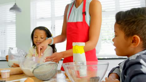 Schwarze-Mutter-mit-seinen-Kindern,-die-Zubereitung-von-Speisen-in-der-Küche-zu-Hause-4k