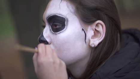 Halloween.-Makeup-artist-applies-make-up-to-female-face