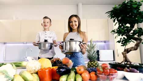 Küche-und-Essen.-Mutter-und-Sohn-halten-einen-Topf-zum-Kochen.