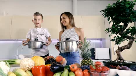 Küche-und-Essen.-Mutter-und-Sohn-halten-einen-Topf-zum-Kochen.