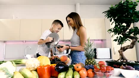 Küche-und-Essen.-Mutter-und-Sohn-halten-einen-Topf-zum-Kochen.