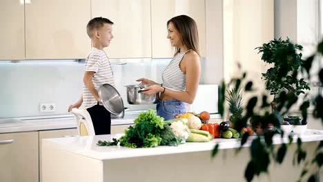 Küche-und-Essen.-Mutter-und-Sohn-halten-einen-Topf-zum-Kochen.