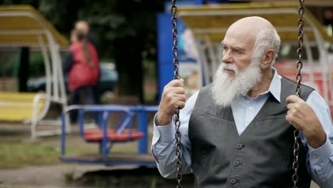 Gloomy-grey-haired-old-man-swings-in-slowmotion