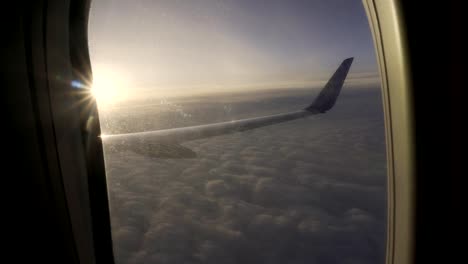 Puesta-de-sol-en-el-cielo-de-la-ala-ventana-del-aeroplano-del-plano.