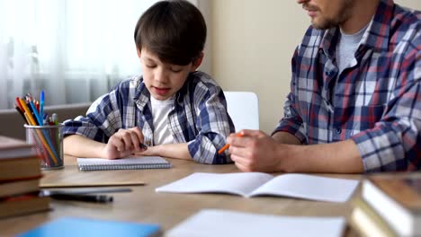 Father-and-son-doing-homework-together,-dad-explaining-task,-school-education