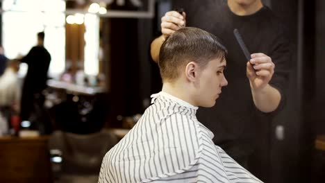 Professional-barber-makes-a-stylish-haircut-for-young-guy