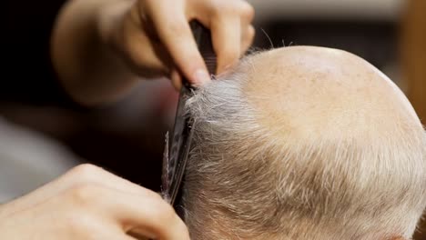 Stylist-cuts-grey-hair-with-scissors-to-mature-man