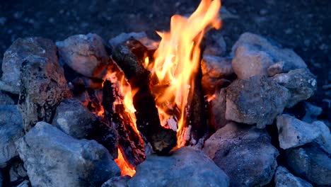 Lagerfeuer-in-ein-Lagerfeuer-von-Steinen-im-freien-in-der-Abenddämmerung