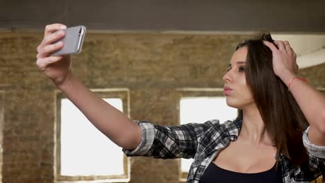 Junge-hübsche-attraktive-Frauen-mit-langen-Haaren,-Foto-mit-ihrem-Handy,-posieren-für-Selfie,-Backsteinbau-Hintergrund