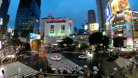 4K-Time-lapse-video-of-people-with-umbrellas-cross-the-famous-diagonal-intersection-in-Shibuya,-Tokyo,-Japan