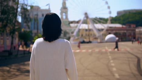 Vista-posterior-de-una-mujer-caminando-por-el-parque-de-atracciones