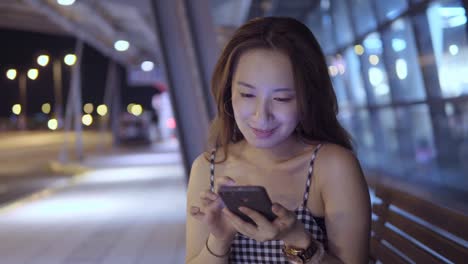 Joven-mujer-de-uso-del-teléfono-móvil-en-el-centro-comercial