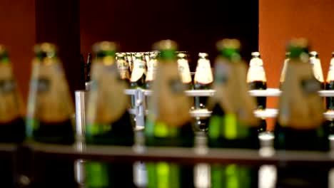 Large-number-of-glass-bottles-with-beer-are-moving-along-the-conveyor.-Low-alcohol-production.-Drinks-are-ready-to-eat.-Factory-equipment-at-work.-The-finished-product-moves-to-another-stage.-Factory-automation.