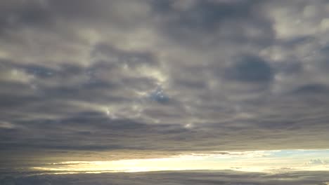 Flugzeug-fliegen-zwischen-zwei-Wolkenschichten-bei-Sonnenaufgang