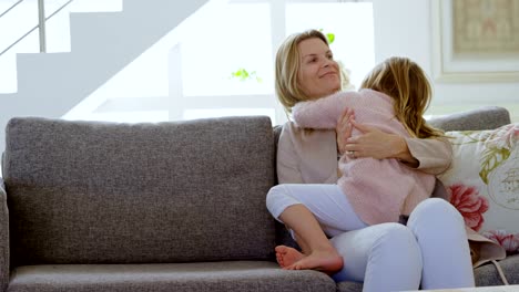 Mother-embracing-her-daughter-in-living-room-4k