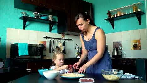 Mutter-und-Tochter-setzen-Salami-auf-dem-Pizzaboden